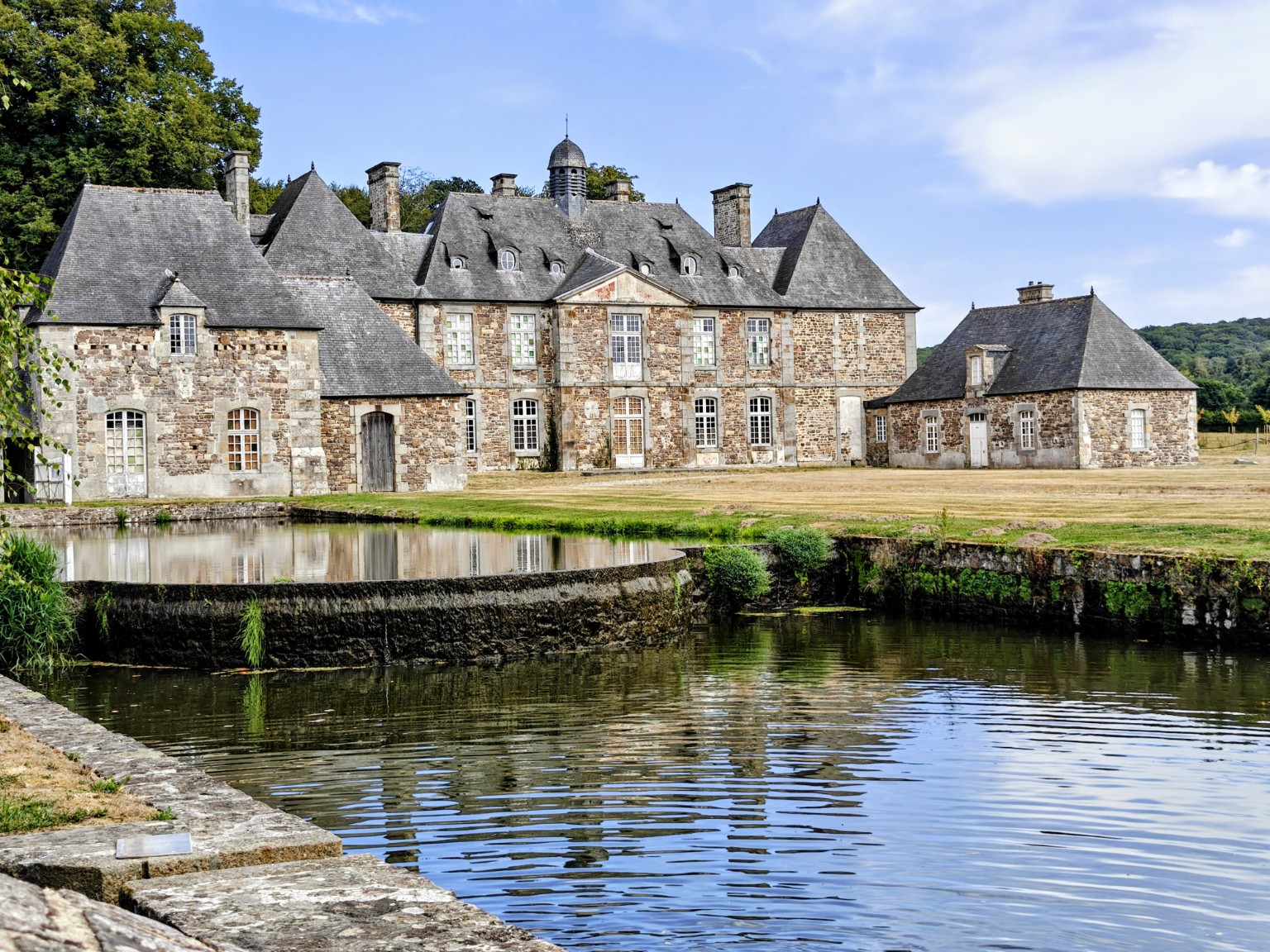 Historic buildings and millpond at La Lucerne Abbey