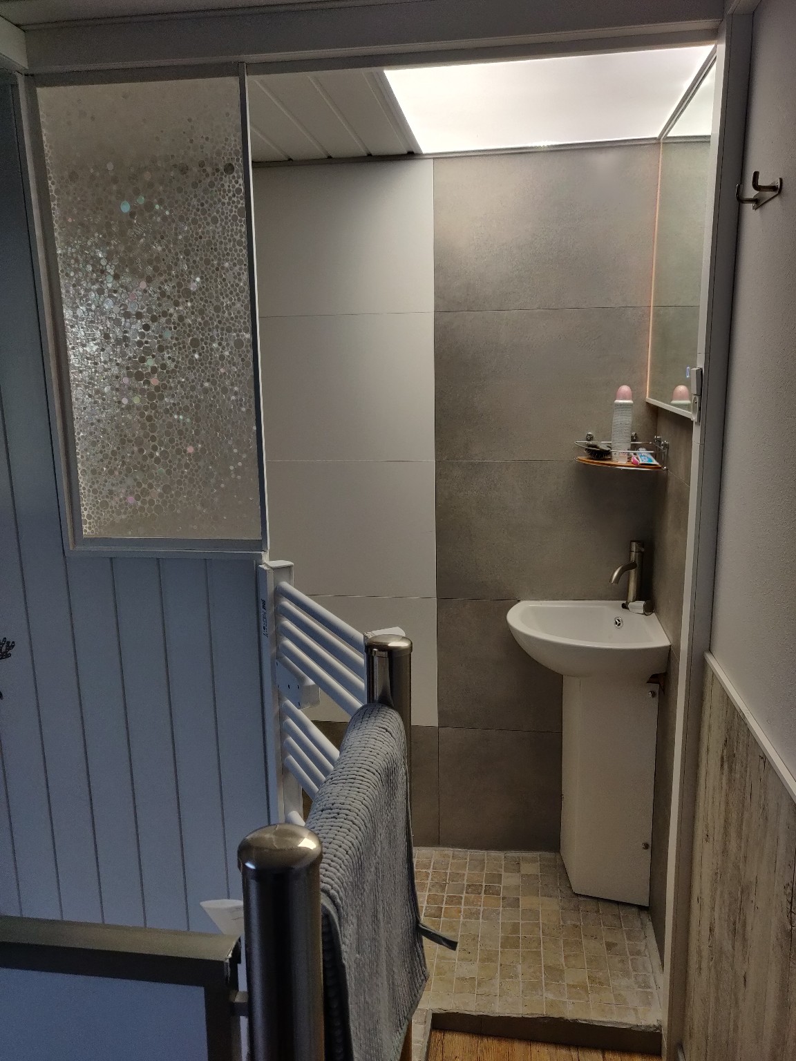 Compact bathroom with basin and shower at Cwtch y Môr